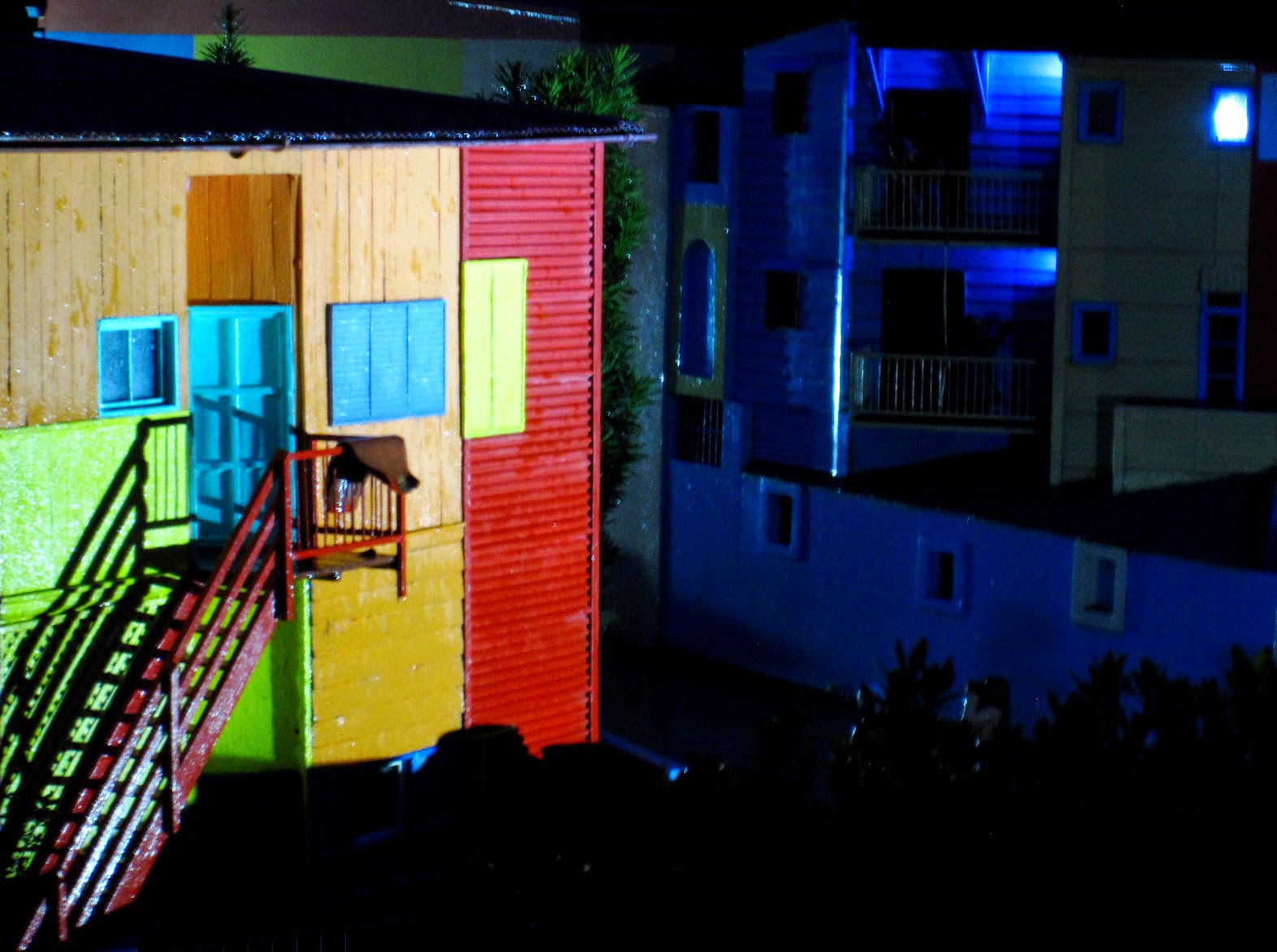 Miniature model of colourfull apartment buildings at night.