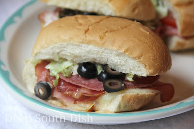 Perfect minis for a party, these sandwiches are layered with provolone cheese, black forest ham, salami and your choice of Italian cold cuts, such as hot capolcollo or mortadella, dressed with creamy Italian dressing, lettuce, tomatoes and olives, if you like.