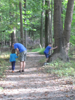 Children and father walking in the woods