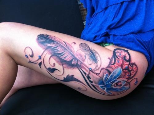 Tatuaje de atrapasueños y plumas en la pierna