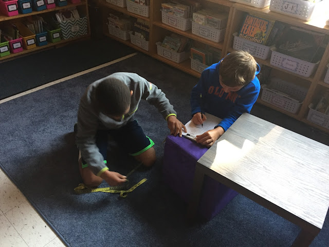two kids measuring stool in classroom