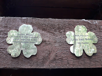 Brass flower plaques mounted on a wooden wall