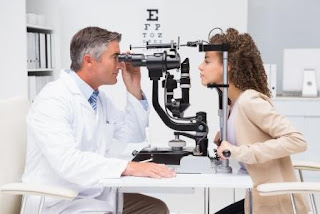 An optometrist is checking eyes of a patient