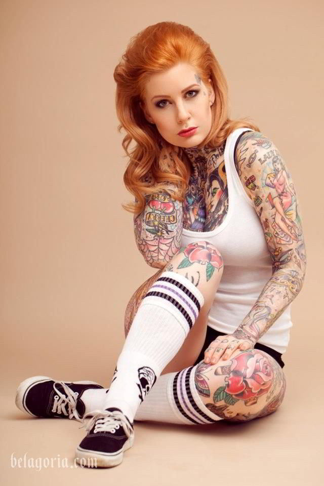 Katy Gold posando con tatuajes de poker, lleva ropa de deporte
