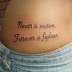 Never a victim forever a fighter quote tattoo on side body 