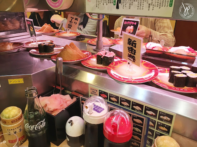 Different types of sushi rotate in front of you at Genroku Sushi - Sennichimae
