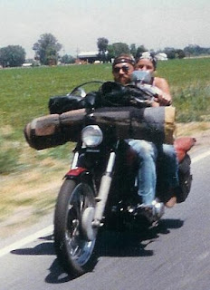 Couple riding a Harley Knucklehead chopper with a homemade bedroll
