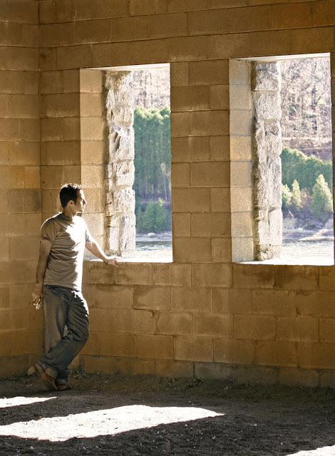 ヨーロッパ風の古い石の建造物の窓から外を観ている男性。