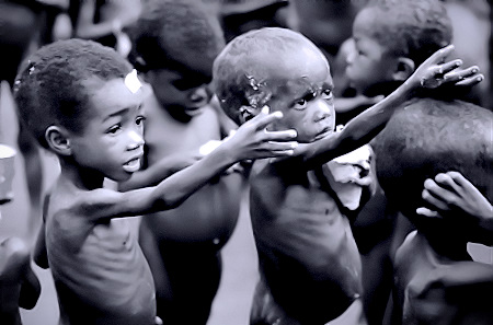 Un grupo de niños africanos extremadamente desnutridos pidiendo comida.