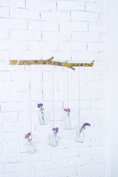 Rama con botellas de cristal y flores