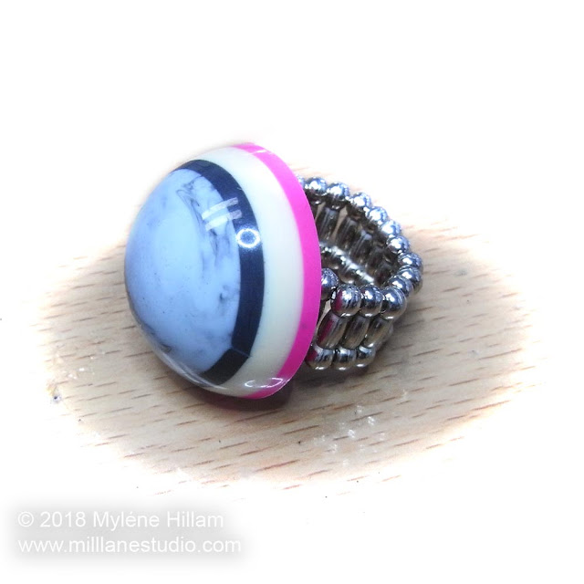 Pink and grey striped bubble ring on a table top