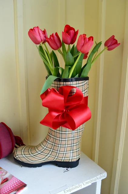 Rain boot with flowers and bow on bench