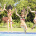 Meiden in bikini springen in zwembad
