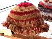 Bucket hat style with red and light brown stripes worked in rounds form the crown. The sides are woven and the hem is fringed.