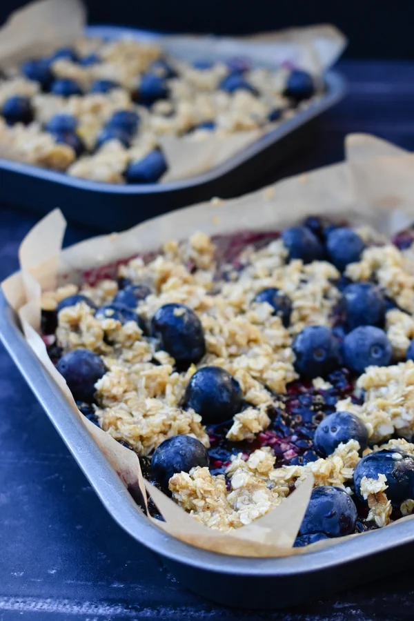 oaty bars topped with blueberries and a crumble topping