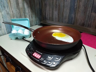 eggs being cooked in a frying pan on an induction cooktop