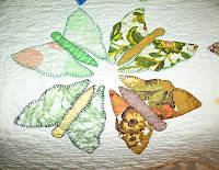 quilt block with four multicolored butterflies made from floral scraps