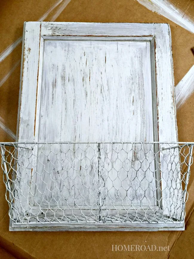 Distressed cabinet door with white basket attached