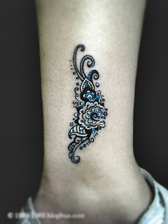 one tribal flower tattoo on the leg near the ankle;