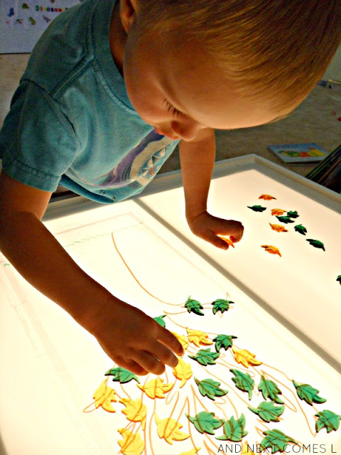Playing with a fall leaf activity on the light table