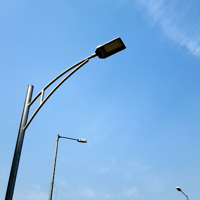 A Minimalist Photo of three street lamps and blue sky shot by Samsung Galaxy S6 Smart Phone