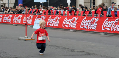 Child running past Coca-Cola signs