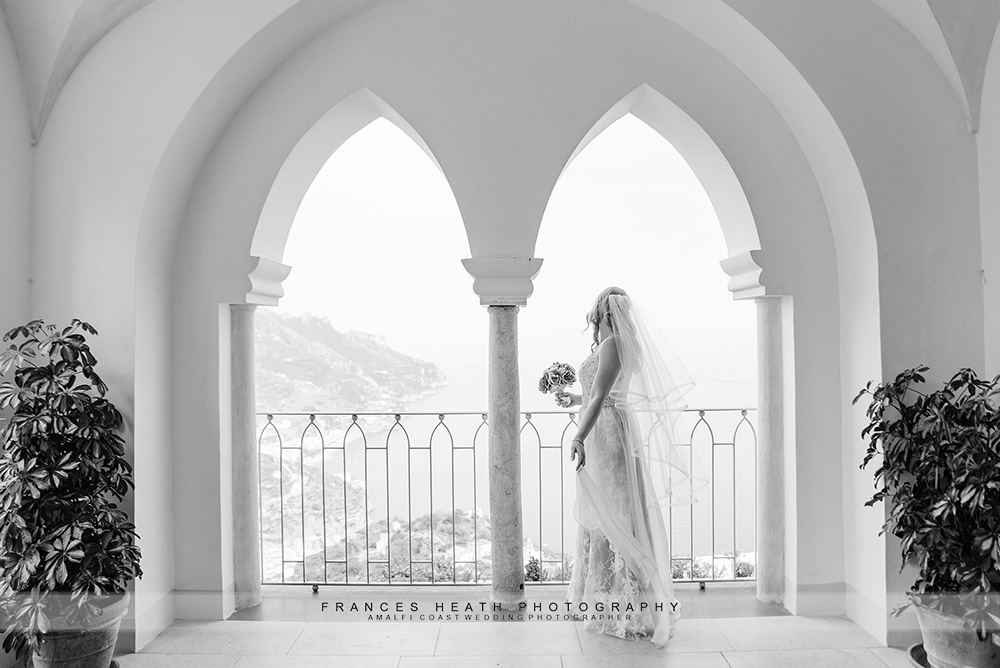 Bride looking out arched window