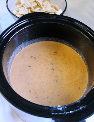 Queso is the ultimate party food and is a must for tailgating and watching the game at home. This tailgate queso is full of flavor and it is super simple to make. slow cooker filled with tailgate queso ready to enjoy