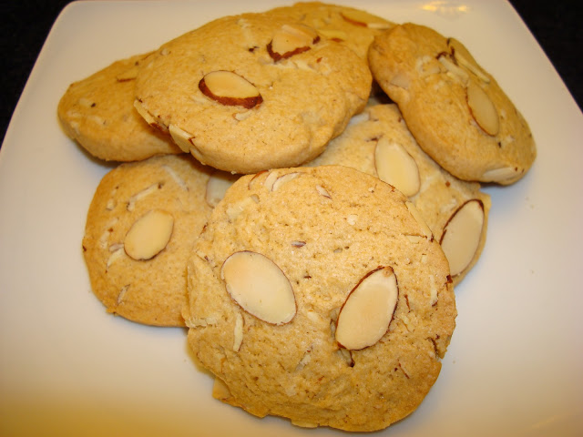 PORCIONES: 26 galletas aproximadamente    INGREDIENTES  2¼ taza de harina.  ¾ taza de azúcar.  ½ cucharadita de bicarbonato.  ¾ taza de mantequilla sin sal.  ⅛ cucharadita de sal.  1 huevo batido.  1 cucharadita de extracto de almendra.  ¾ taza de almendras cortadas en rodajas.    PREPARACIÓN  Precalentar el horno a 400° F - 204° C.  Mezclar en una batidora la harina, azúcar, bicarbonato, mantequilla y sal hasta que se formen bolitas pequeñas.  Agregar, mezclar el huevo y extracto de almendras.  Espolvorear la mesa con harina y extender la masa.  Agregar las almendras, mezclar con la masa y hacer una bola. Rodar la masa hasta formar un rollo de 6 cm de diámetro. Cortar el rollo en círculos de 1 cm de espesor aproximadamente. Poner  los círculos de masa en una bandeja con papel de hornear.  Poner encima de cada galleta 2 rodajas de almendras y presionar un poquito para que se pegue.  Hornear las galletas por aproximadamente 14 minutos.