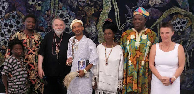 A meeting at the Susanne Wenger Foundation in Austria with Tokumbo, Sangosakin, Wolfgang Denk (founding director), Babalorixá Anderson Argolo from Salvador da Bahia, Wenger's daughter Adedoyin Faniyi Olosun, Wenger's son Sangodare Gbadegesin Ajala and Silvia Jura. In the background a huge batik of Susanne Wenger.