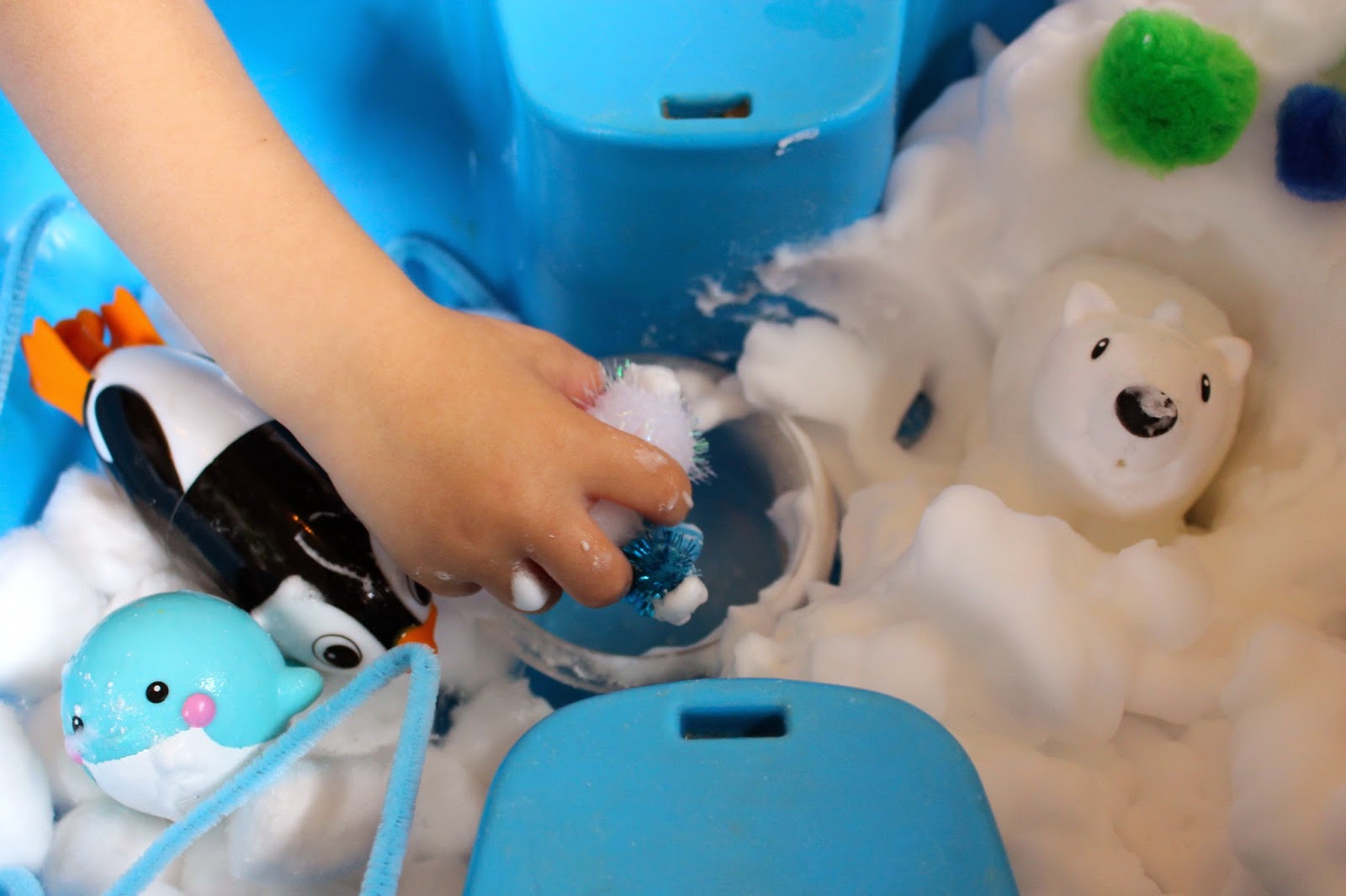 Snowy sensory play activity for toddlers and preschoolers.  Create a simple small world winter snow scene using foam soap, penguins and polar bears.