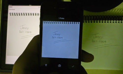 Fotografia do smartphone com a nota fotografada. A esquerda dele, o tablet mostrando a mesma informação que está no bloco de notas, do lado direito.