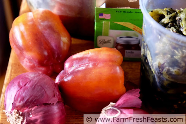 a photo of the ingredients for peach salsa, showing orange-purple peppers, red onions, and roasted Hatch chiles with a box of Ball jar lids