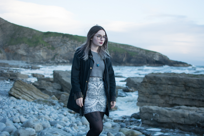 portrait of a girl on the beach long sleeve crop top black milk ancient maps bodycon dress big hipster glasses crystal necklace