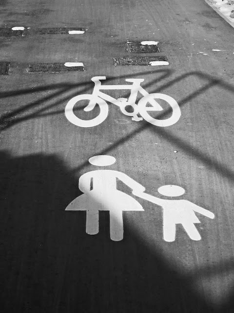 White paintings on tarmac show it's a path for cyclists and pedestrians.