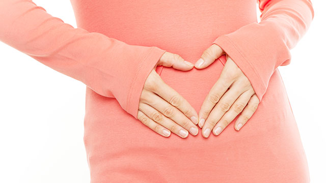 Image of a person holding their stomach signaling nutritional regulation for inflammatory bowel disease.