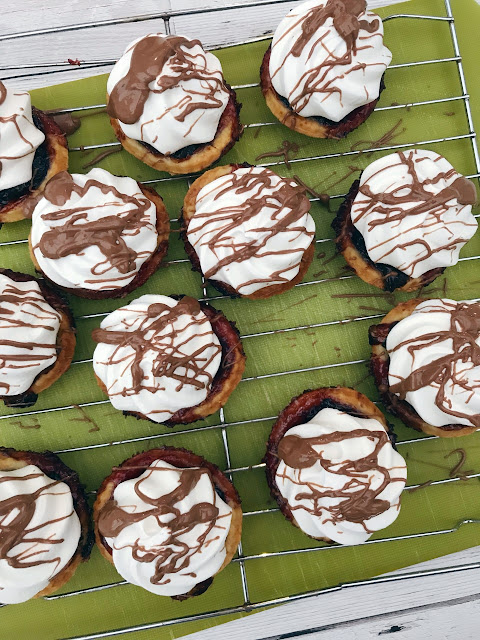 tarts with chocolate being drizzle over them