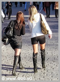 Girls in black high heels boots on the street 