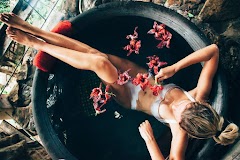 Relaxing in round outdoor bath with tropical flowers.