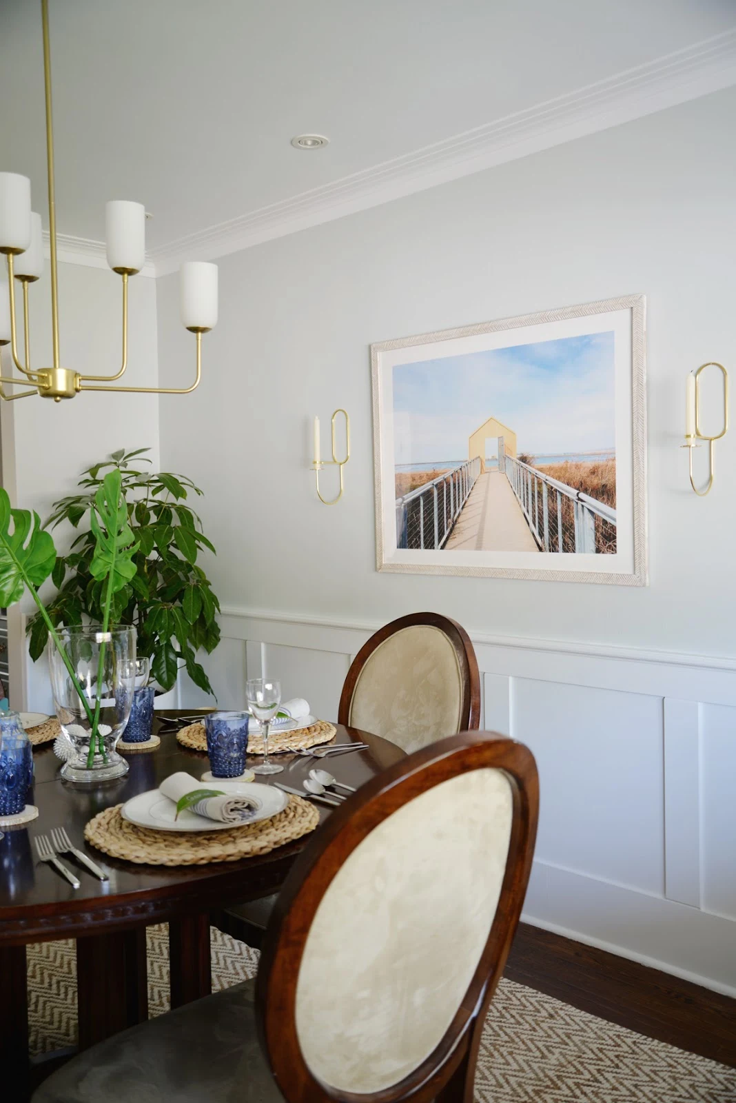 Rambling Renovators | tropical dining room, Lup Oblong Wall sconce, round dining table, Hinkley Harlow chandelier