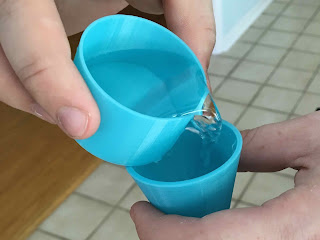 Photo of pouring water from one model into another to show they are the same volume