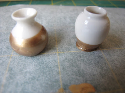 Two gold-dipped dolls- house white vases.