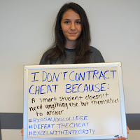 photo of a student holding up white board with her statement, I don't cheat because a smart student doesn't need anything else but themselves to answer