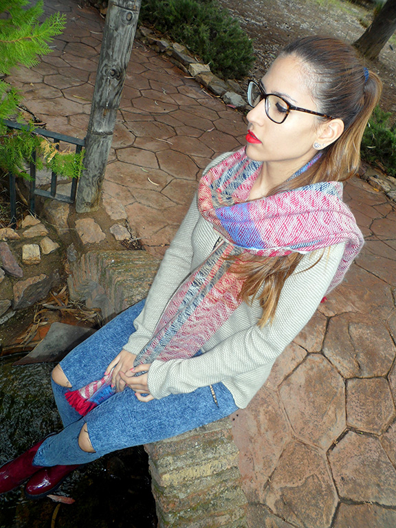 Maxi jersey asimétrico con vaqueros rasgados, botines burdeos, maxi bufanda y reloj