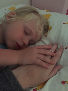Little girl falling asleep holding her mothers hand