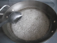 Stirring sugar water mixture in pan on stove