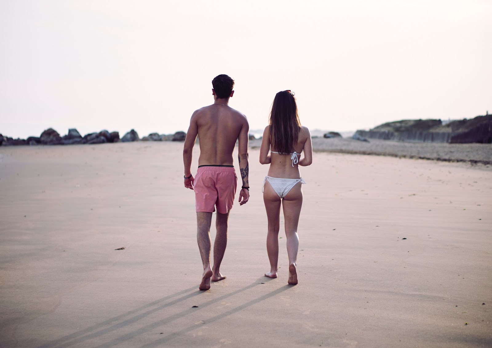 Man and woman walking down a beach