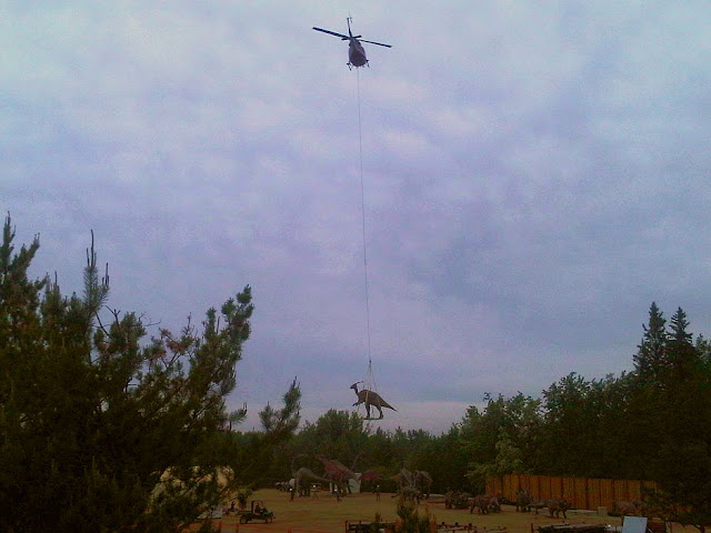 dinosaurios siendo transportados en helicoptero