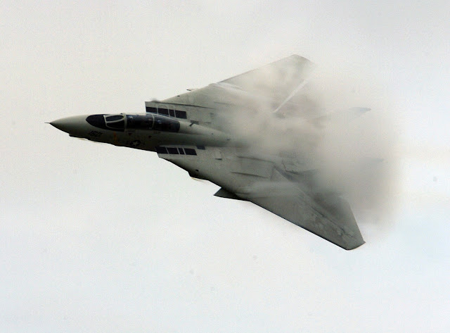 F-14D in a high-speed flyby causing vapor to form