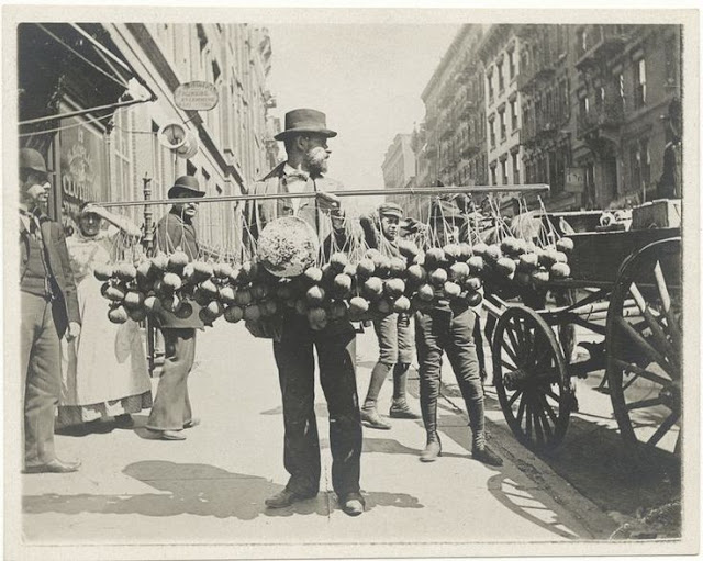 Vintage photo Street Vendor New York 1890s. A man offers balls of cheese tied to large pole. Jingles and other stories of The American Dream. marchmaton.com Vintage photo Street Vendor New York 1890s. A man offers balls of cheese tied to large pole. Jingles and other stories of The American Dream. marchmaton.com